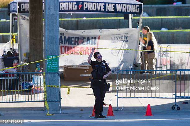 Police officers and FBI agents walk through the courtyard at Utah Valley University as authorities search for the man who killed political activist...