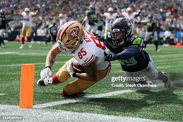 George Kittle of the San Francisco 49ers scores a touchdown against Ty Okada of the Seattle Seahawks during the first quarter during the game at...