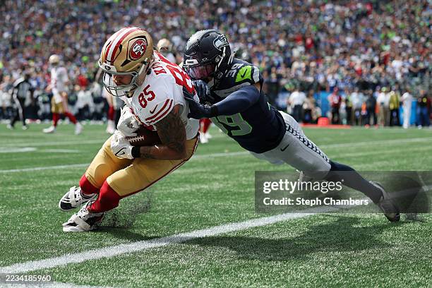 George Kittle of the San Francisco 49ers scores a touchdown against Ty Okada of the Seattle Seahawks during the first quarter during the game at...