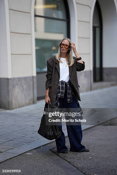 Mirja Klein is seen wearing an oversized chocolate-brown Peoria faux suede blazer with notch lapels, flap pockets and padded shoulders from The...