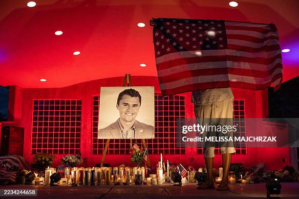People pay their respects during a candlelight vigil for youth activist and influencer Charlie Kirk at a makeshift memorial at Orem City Center Park...
