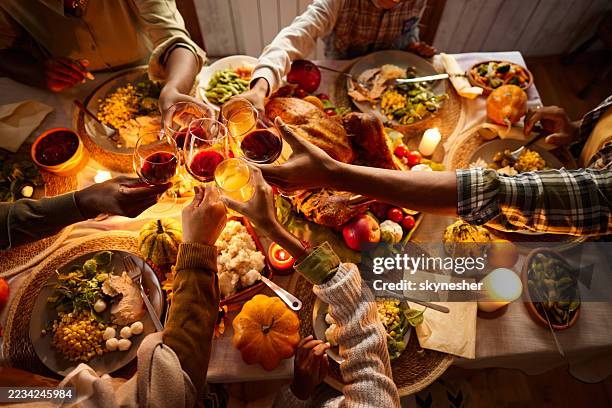 unrecognizable black family toasting during thanksgiving lunch. - thanksgiving bildbanksfoton och bilder