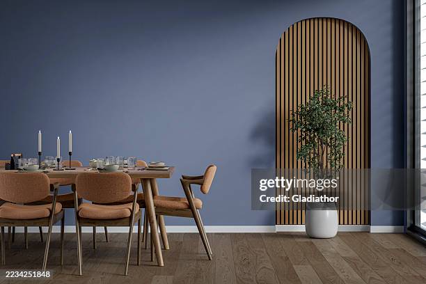 a modern but retro dining room with a full (set) table and chairs in front of a lilac (lavender) wall and a potted plant in front of a wooden arched alcove, near a window, '70s retro style furniture - renovation of upholstered furniture stock pictures, royalty-free photos & images