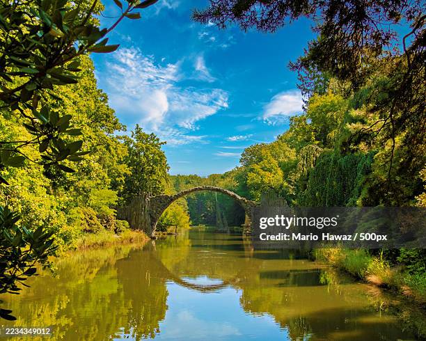 picturesque view of rakotz bridge reflecting in a tranquil lake,germany - kromlau azalea and rhododendron park foto e immagini stock