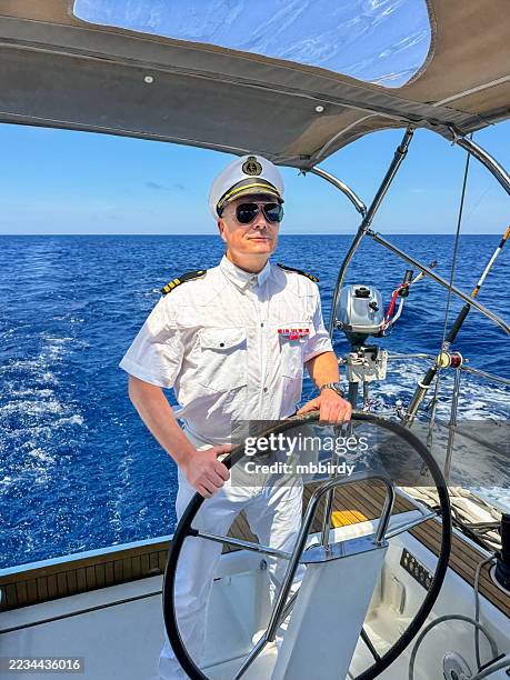 skipper dressed like an admiral on sailboat - team captain stock pictures, royalty-free photos & images