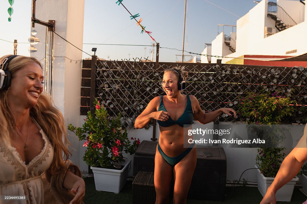 Friends enjoying silent disco on rooftop terrace