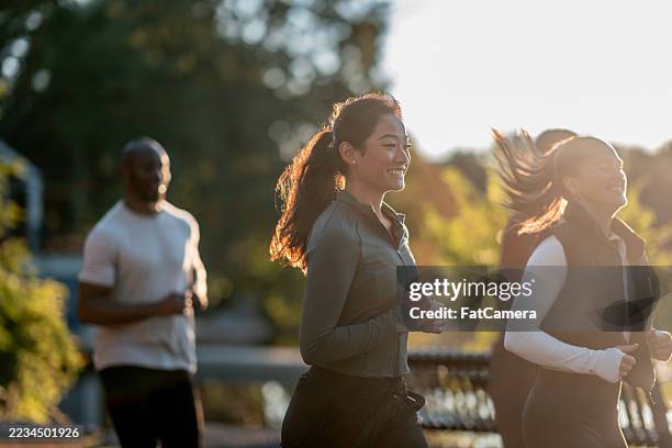 diverse group running together outdoors during a sunny day - individual event stock pictures, royalty-free photos & images