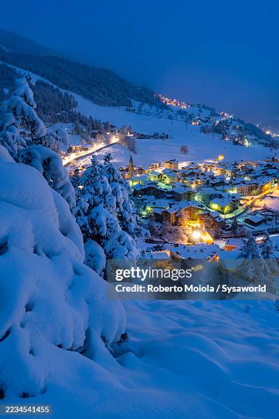 alpine ski resort of bormio in deep snow at dusk - bormio foto e immagini stock