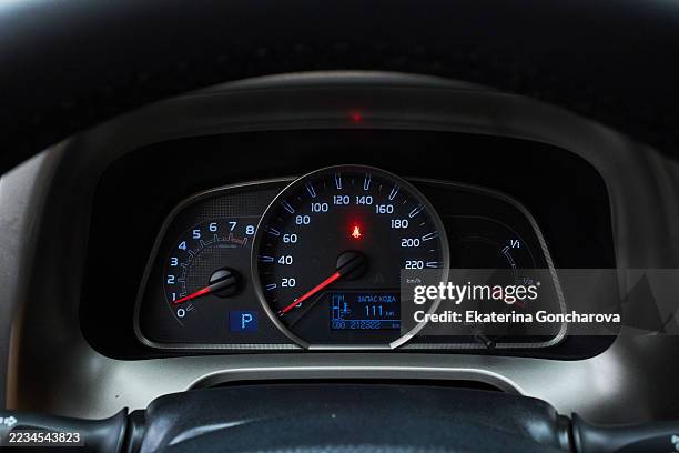 close-up of an illuminated automobile dashboard showing speedometer and fuel indicators - cuadro de instrumentos fotografías e imágenes de stock