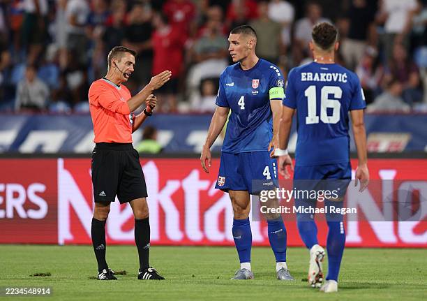 Nikola Milenkovic of Serbia interacts with Referee Clement Turpin after being shown a red card for a tackle on Harry Kane of England during the FIFA...