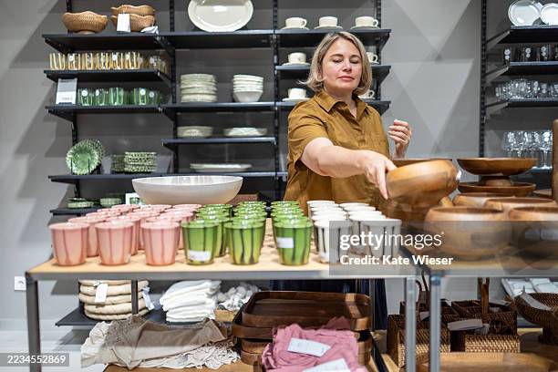 mature woman shopping for kitchenware in a store. - équipement domestique photos et images de collection