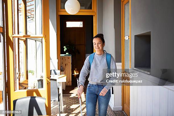 smiling young blind woman walking with a white cane in a cafe - visual impairment stock pictures, royalty-free photos & images