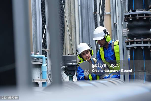 engineer under checking the industry cooling tower air conditioner is water cooling tower air chiller hvac of large industrial building to control air system - compressor stockfoto's en -beelden