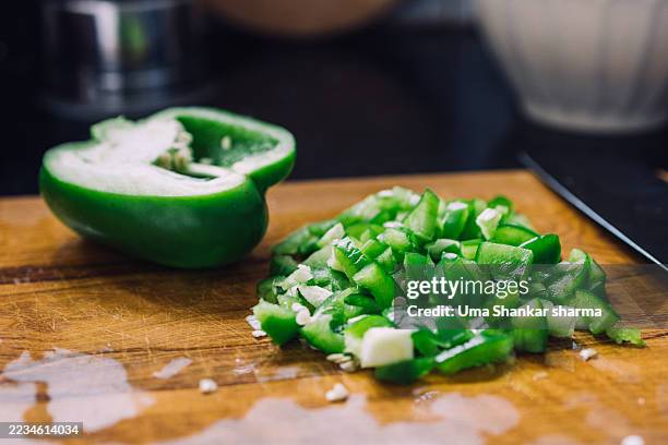 chopped green bell pepper on wooden cutting board - chopped herbs stock pictures, royalty-free photos & images