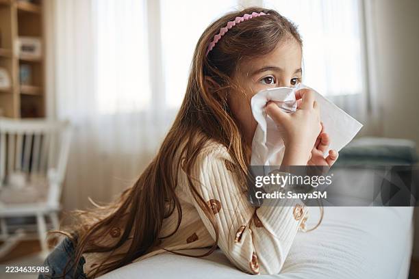 sick girl with tissues - tissue stockfoto's en -beelden