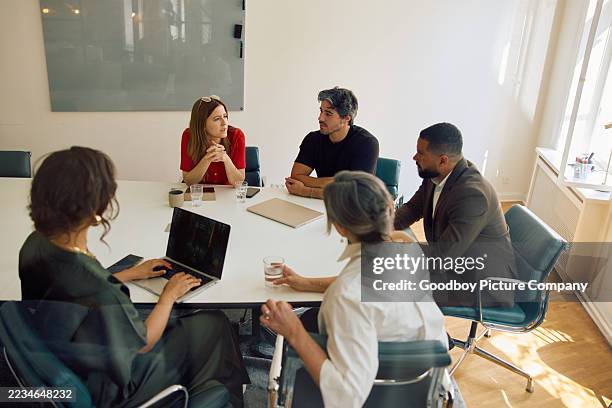 high angle view of diverse business team collaborating on ideas in bright modern meeting room - conferentietafel stockfoto's en -beelden