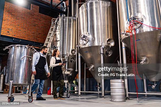 coworkers talking and walking at brewery - brewery stock pictures, royalty-free photos & images