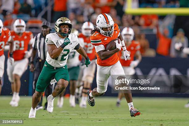 Miami Hurricanes wide receiver Tony Johnson as South Florida Bulls safety Jabari Smith looks on during the college football game between the Miami...