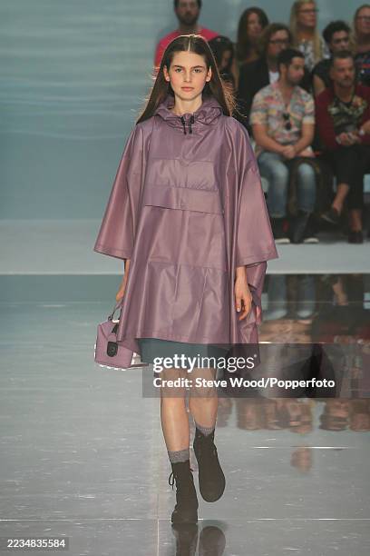 Model walks the runway at the Hunter Original show during London Fashion Week Spring/Summer 2015, she wears a teal skirt and a long lilac poncho...