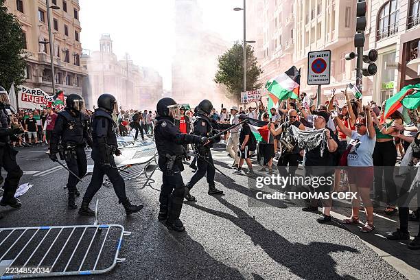 Police face Pro-Palestinians protestors after security barriers were taken down during the 21st and last stage of the Vuelta a Espana 2025, a 101 km...