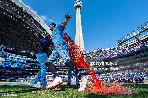 Ernie Clement of the Toronto Blue Jays gets doused in Gatorade by teammate Vladimir Guerrero Jr. #27 in the post game interview following their...