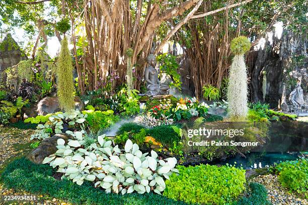 buddha statue outside on nature and green background. - lotus position stock pictures, royalty-free photos & images