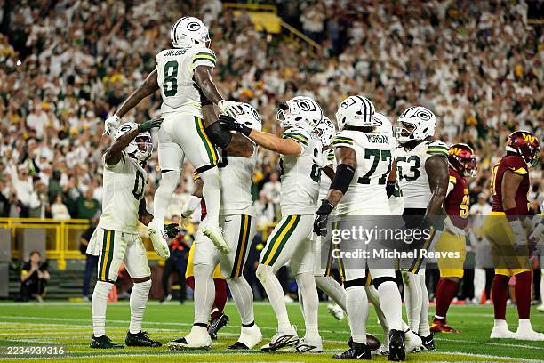 Josh Jacobs of the Green Bay Packers celebrates with his teammates after scoring a touchdown against the Washington Commanders during the second...