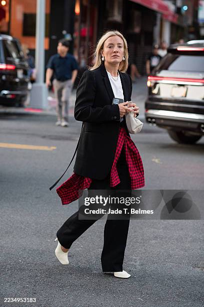 Guest is seen wearing a black blazer, white top, pearl earrings, plaid shirt, black pants, white heels and carrying a white bag outside the...