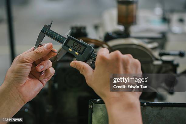 primer plano del calibrador digital que mide el componente metálico en la fábrica - calibrador fotografías e imágenes de stock