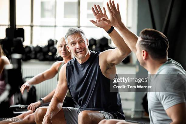 two mature male athletes celebrating with high five during cross training workout - mannelijke vriendschap stockfoto's en -beelden