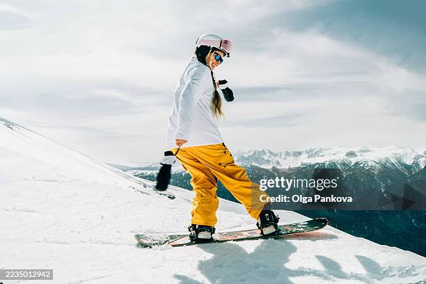 snowboarder woman enjoying sunny day on mountain - snowboard stockfoto's en -beelden