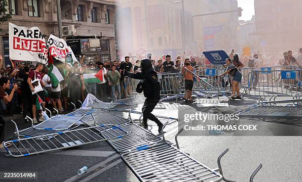 Policeman uses pepper spray on Pro-Palestinian protestors as they break through barriers and invade the street forcing race organisers to abandon the...