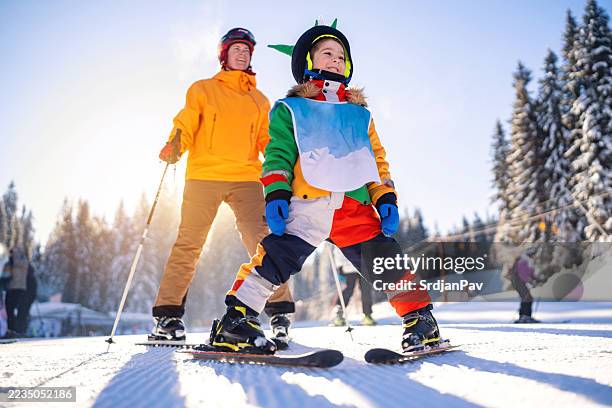 child learning to ski with his mother on a sunny winter day - family skiing stock pictures, royalty-free photos & images