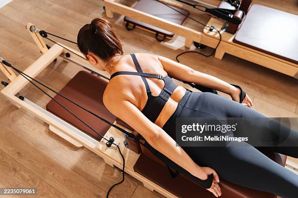mujer de arriba haciendo pilates en reformer - equipo de formación fotografías e imágenes de stock