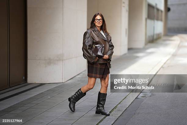 Anna Winter is seen wearing a dark brown oversized leather jacket with a structured biker-inspired cut from Ducie London; a plain white t-shirt with...