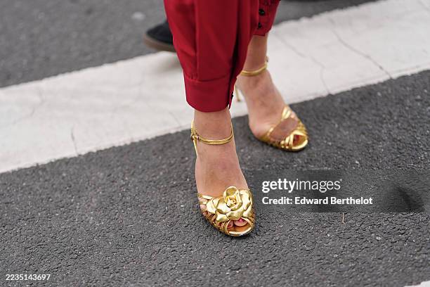 Guest wears red puffy pants, gold shiny leather scrappy high heels shoes, outside Area, during New York Fashion Week, on September 12, 2025 in New...