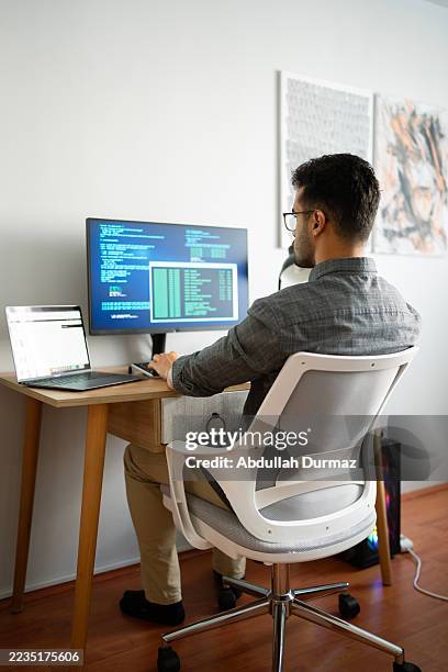 computer programmer writing code on computer at home office - software development stock pictures, royalty-free photos & images