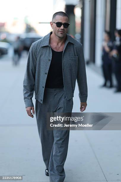 Guest seen wearing black rectangular sunglasses, black crew-neck cotton basic tank top, relaxed grey wool jacket with a pointed collar, single chest...