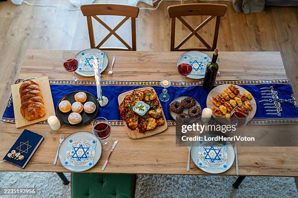 la famille célèbre hanoukka avec de la nourriture et des décorations traditionnelles - juif photos et images de collection