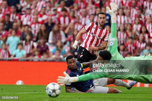 Athletic Bilbao's Spanish forward Alex Berenguer shoots past Arsenal's Brazilian defender Gabriel as Arsenal's Spanish goalkeeper David Raya reaches...