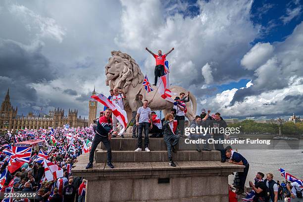 Protesters wave Union Jack and St George's England flags during the "Unite The Kingdom" rally on Westminster Bridge by the Houses of Parliament on...