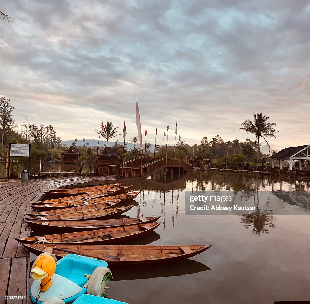 Seeszene mit Holzbooten bei Sonnenaufgang