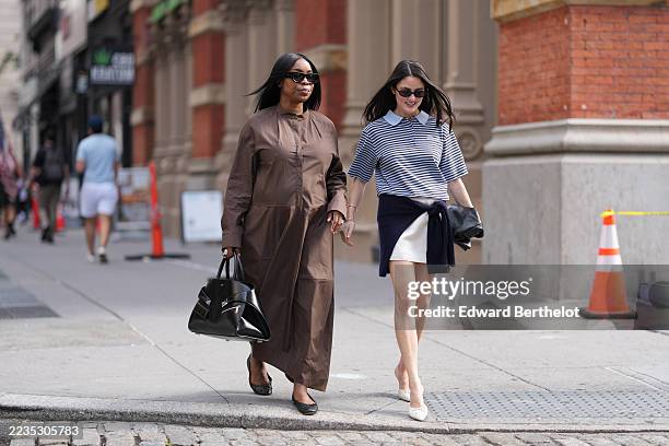 Guest wears straight shoulder-length black hair parted in the middle, black oversized rectangular sunglasses, a structured black leather top-handle...