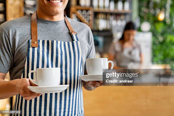 kellner mit einer tasse kaffee in einem café - kantinenfrau stock-fotos und bilder