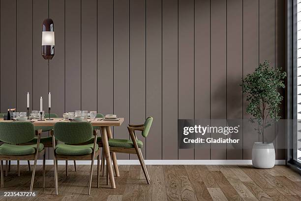 a modern but retro dining room with a full (set) table and chairs in front of gray brown shiplap wall, a potted plant near a window, '70s retro style furniture - renovation of upholstered furniture stock pictures, royalty-free photos & images