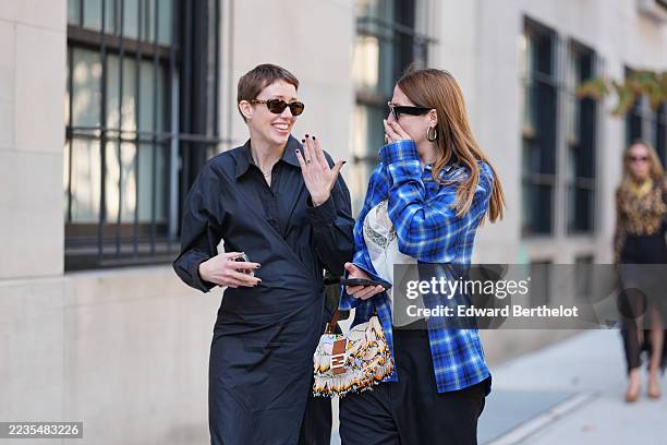 Guest wears black sunglasses, a gold necklace, a black shirt, a black knees pencil skirt, a dark brown shoulder bag, a guest wears long straight...