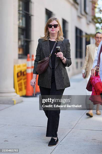 Guest wears shoulder-length blonde hair worn loose with a slight wave, dark brown tortoiseshell sunglasses with rounded square frames, a thin gold...