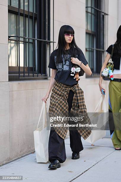 Guest wears long straight black hair with blunt bangs, purple-tinted rectangular sunglasses, a thin silver chain necklace and a silver bracelet, a...