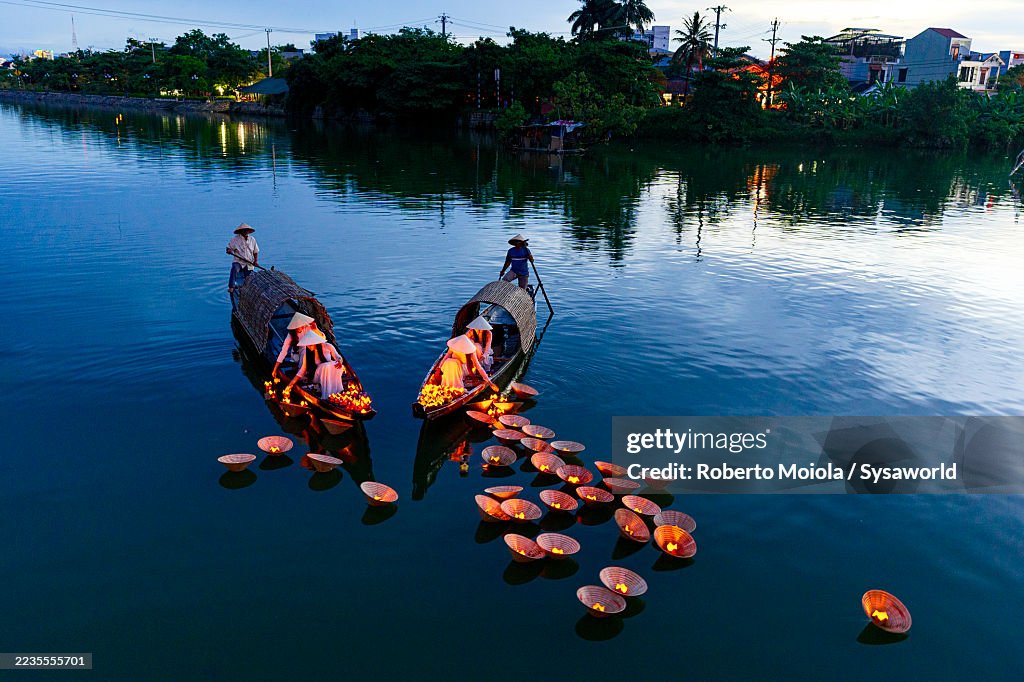 Women placing floating lanterns in Nhu Y River, Hue