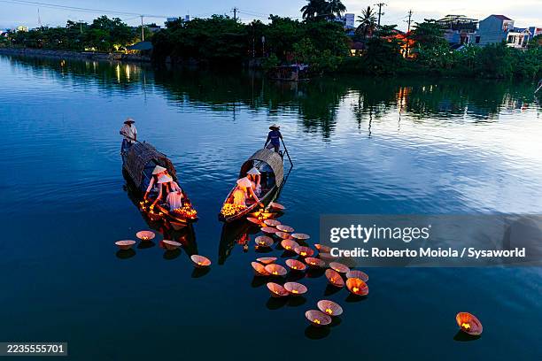 women placing floating lanterns in nhu y river, hue - vietnamese culture stock pictures, royalty-free photos & images